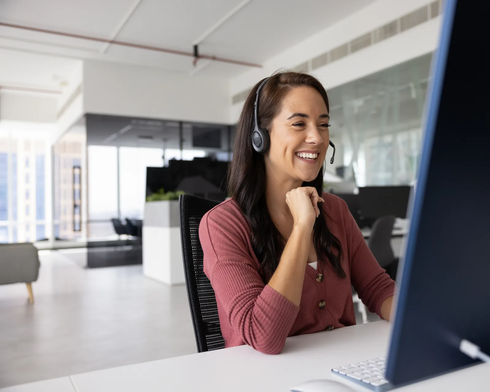A NextRCM virtual staffing specialist wearing a headset at her desk